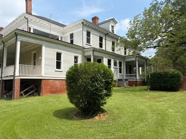 A historic Columbia home with a freshly maintained lawn and shrubs